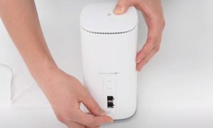 ホームルーターに電源アダプタを接続する様子