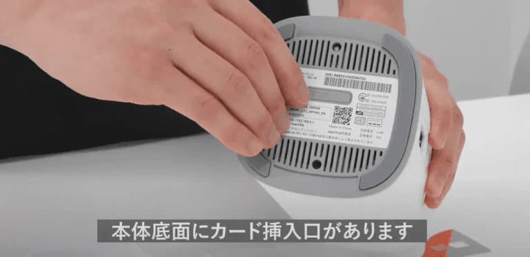 本体底面にあるカード挿入口を開けている様子