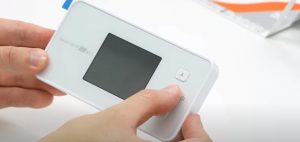 モバイルルーターの電源ボタンを長押ししている様子